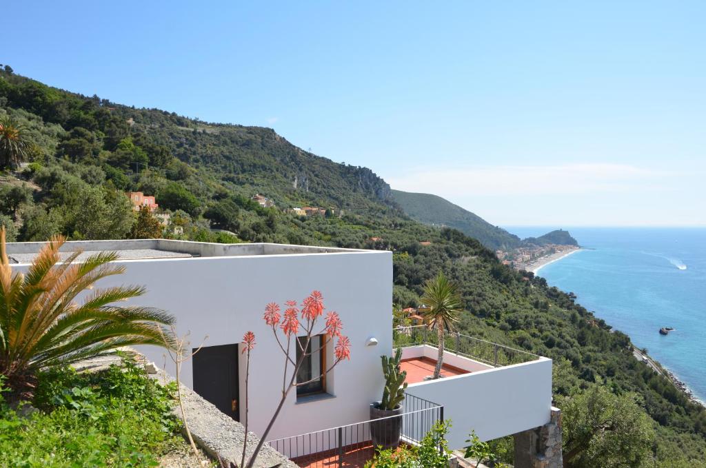 a white house on a hill overlooking the ocean at Villa Ca' Bianca in Finale Ligure