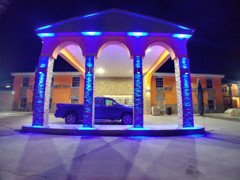 a truck parked under an arch with blue lights at Alien Residence Inn in Pecos