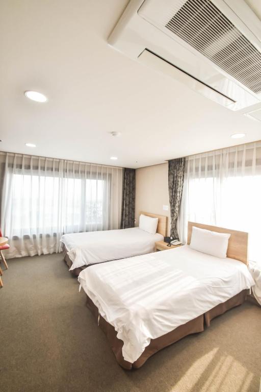 Postel nebo postele na pokoji v ubytování Dream Jeju Hotel