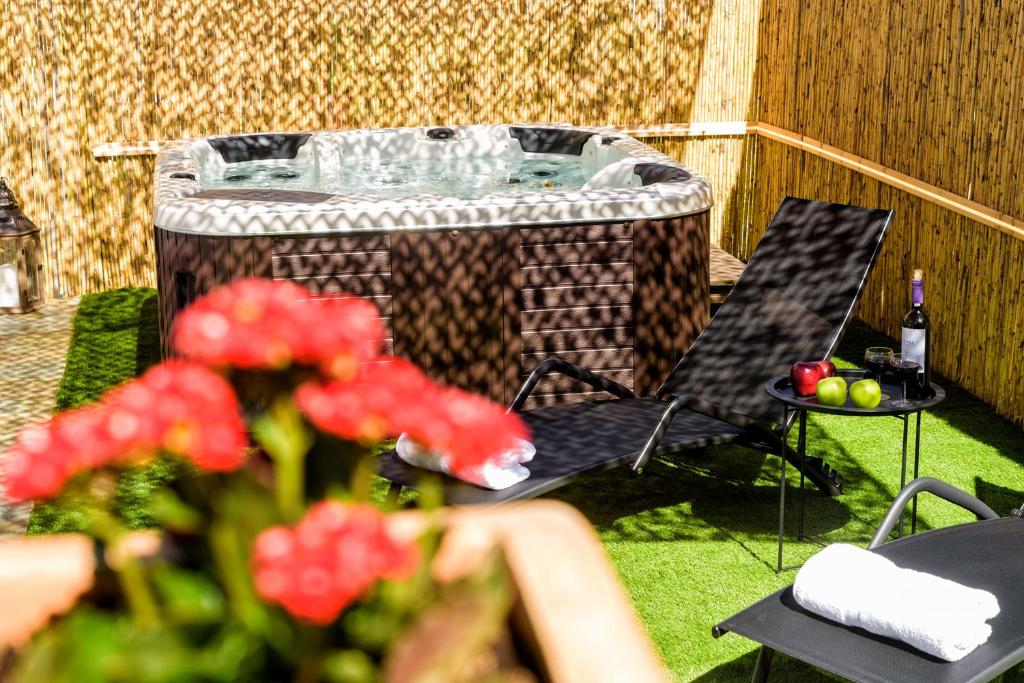 a backyard with a hot tub and a table with red flowers at Louros Spa House in Mármara