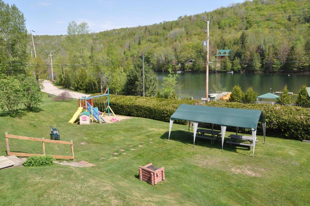 a backyard with a playground and a ping pong table at Le Boisé du Lac in Mont-Tremblant