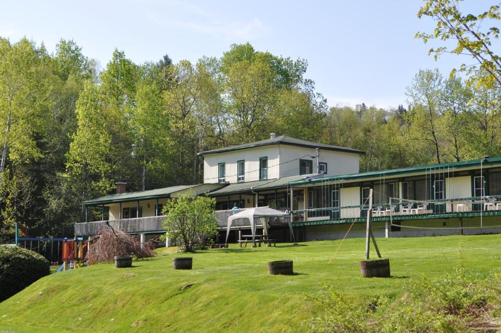 a large house with a lawn in front of it at Le Boisé du Lac in Mont-Tremblant