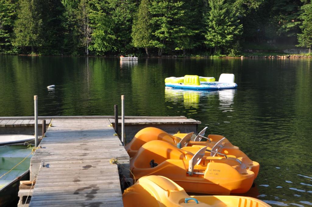 a group of inflatable boats parked at a dock on a lake at Le Boisé du Lac in Mont-Tremblant