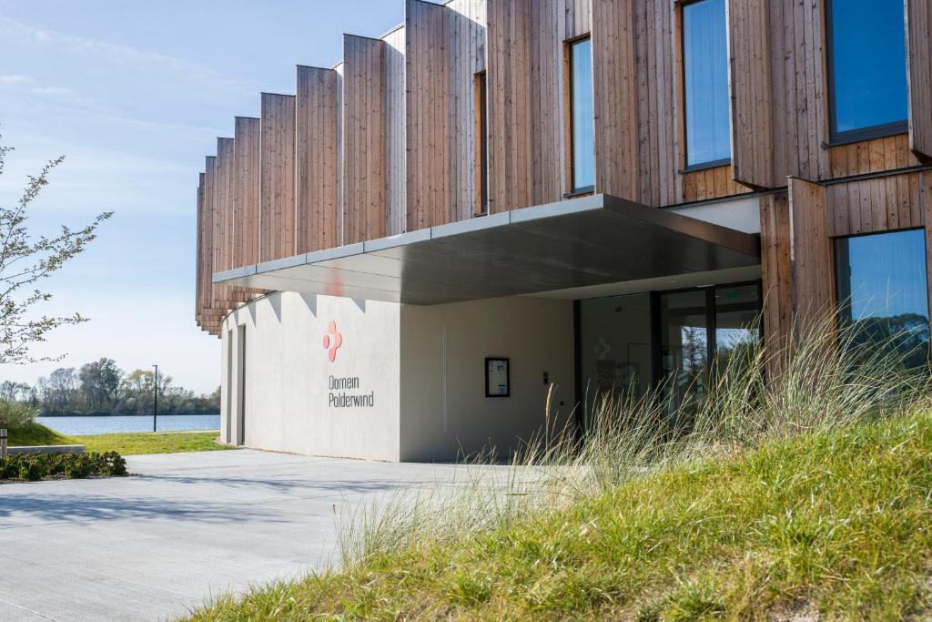 um edifício com painéis de madeira na lateral em Domein Polderwind em Zuienkerke