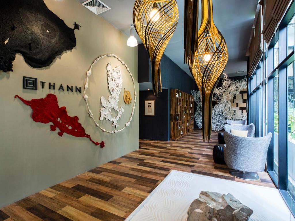 A design-led corridor features sculptural hanging lights, artwork, seating and tall windows.