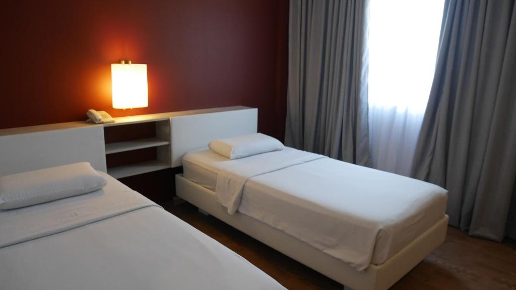 Postel nebo postele na pokoji v ubytování Circle Inn Hotel and Suites Bacolod