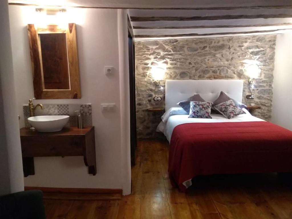 a bedroom with a bed and a bathroom with a sink at Casa Piñana in Anciles
