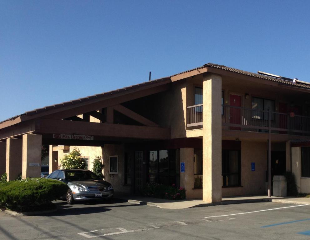 a hotel with a car parked in a parking lot at Motel 6 Soledad, CA in Soledad