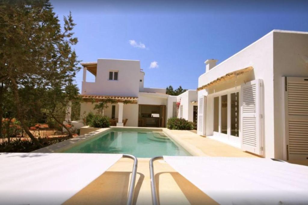 a swimming pool in front of a house at K-Mari Villa Formentera in Playa Migjorn