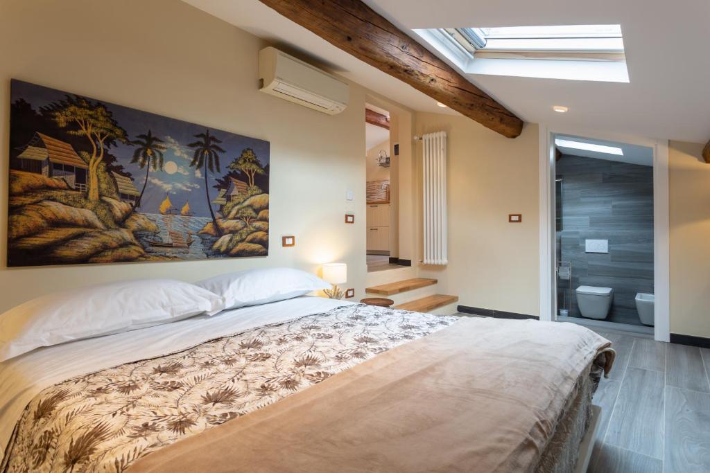 een slaapkamer met een groot bed en een schilderij aan de muur bij Le stanze di Carla! Con cucina e bagno privato in Florence