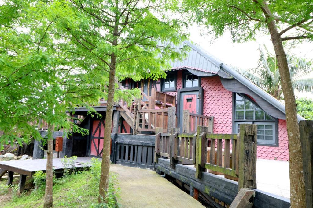 a pink house with a wooden fence in front of it at Fanlin House in Jialin