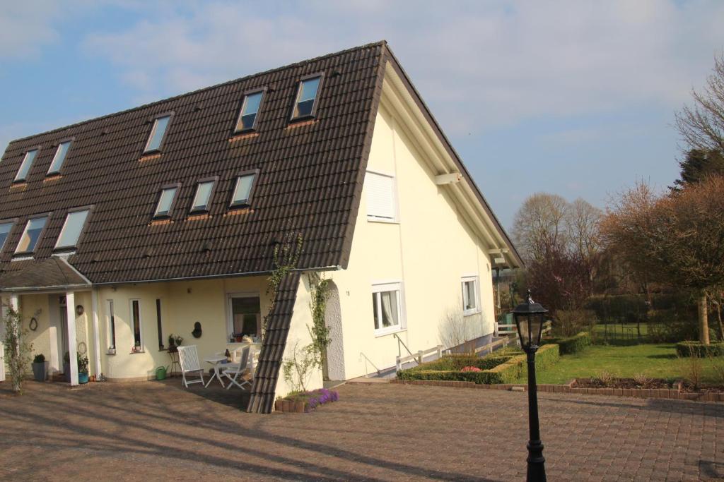 une grande maison blanche avec un toit en gambrel dans l'établissement Ferienwohnung Nett, à Blankenheim
