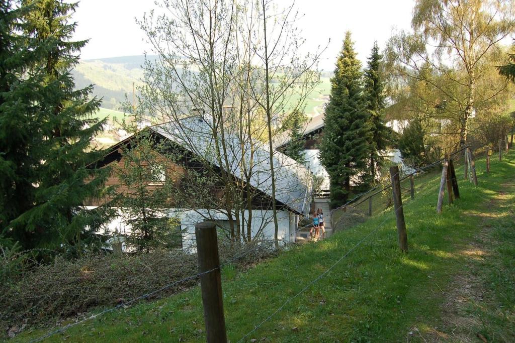 una cerca frente a una casa en una colina en Haus Bergzicht en Schwalefeld