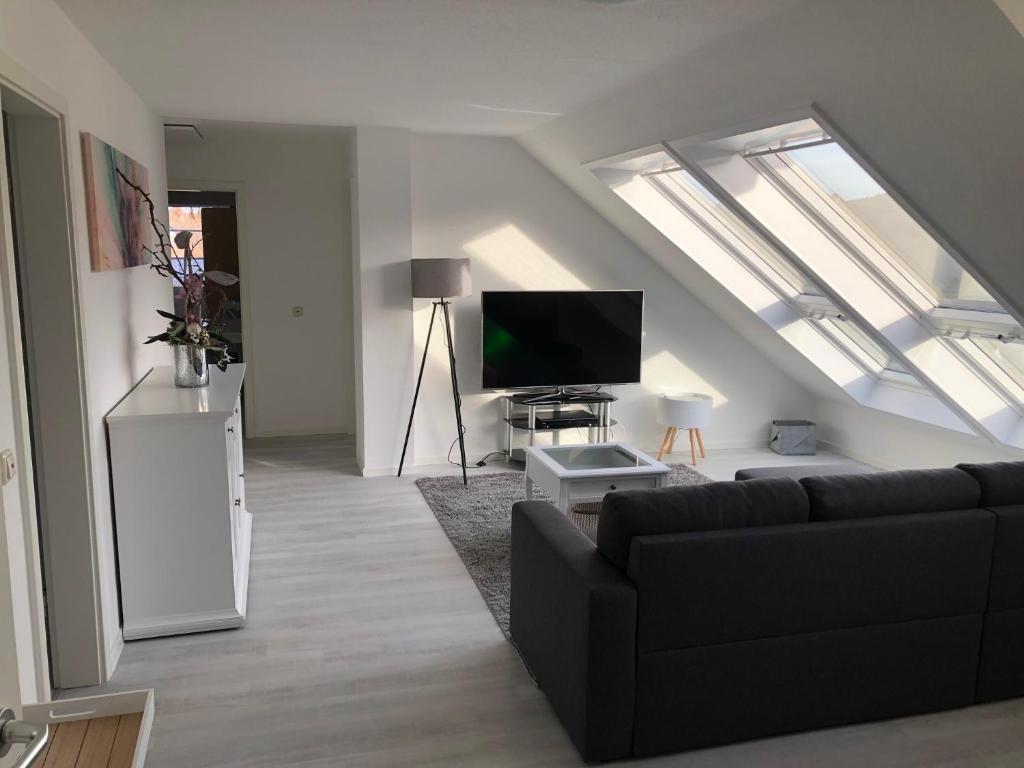 a living room with a couch and a flat screen tv at eifelTIME - Ferienwohnung in Bad Münstereifel