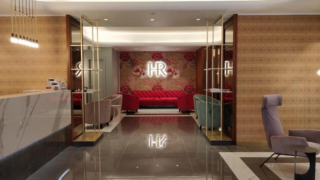 a hotel lobby with a red couch in the middle at Hotel Roma in Trieste