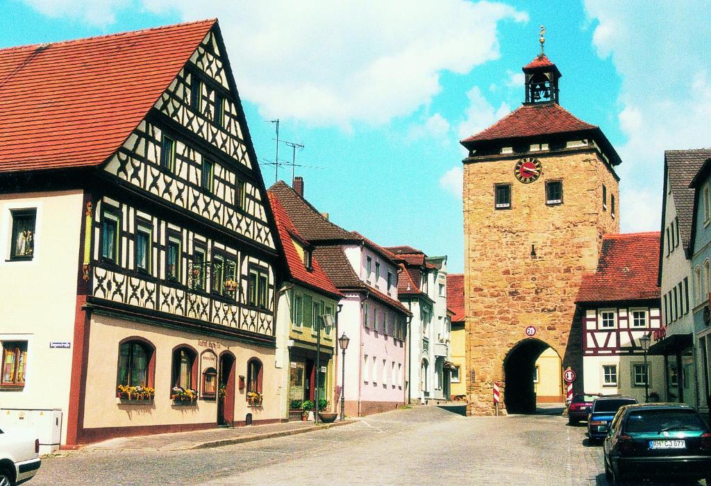 una calle de la ciudad con edificios y una torre del reloj en Hotel-Gasthof Krone-Lax en Scheinfeld