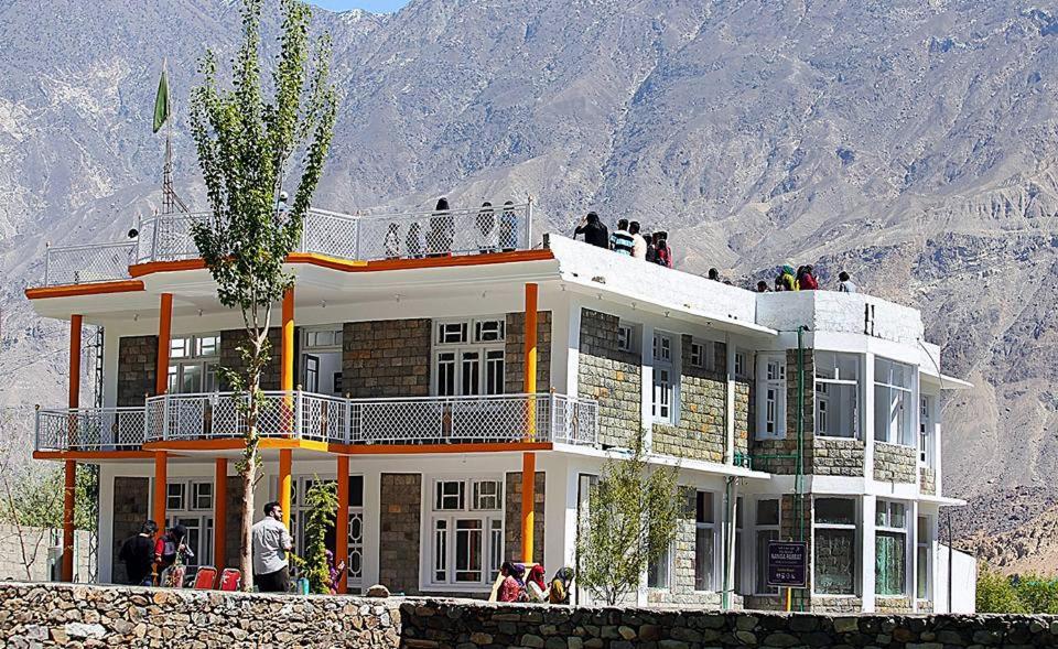 - un grand bâtiment blanc avec des personnes sur le balcon dans l'établissement Junction Resort, à Jaglot