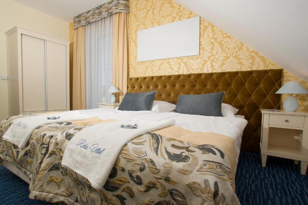a bedroom with a large bed with a large headboard at Reha Vital in Stare Siołkowice