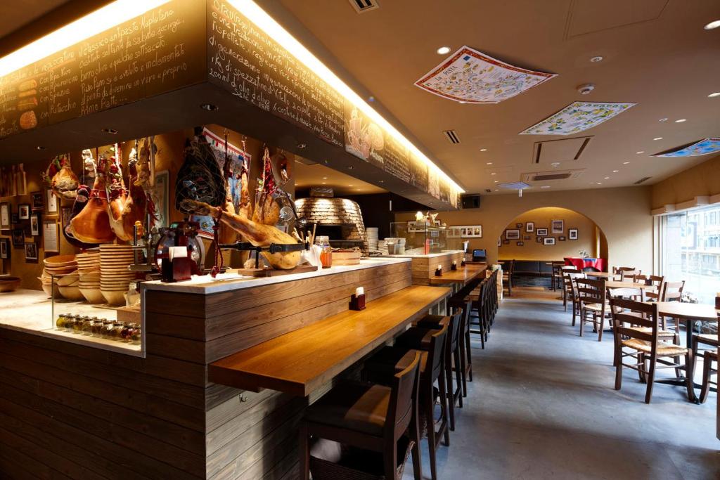 a restaurant with a long bar with tables and chairs at the b ikebukuro in Tokyo