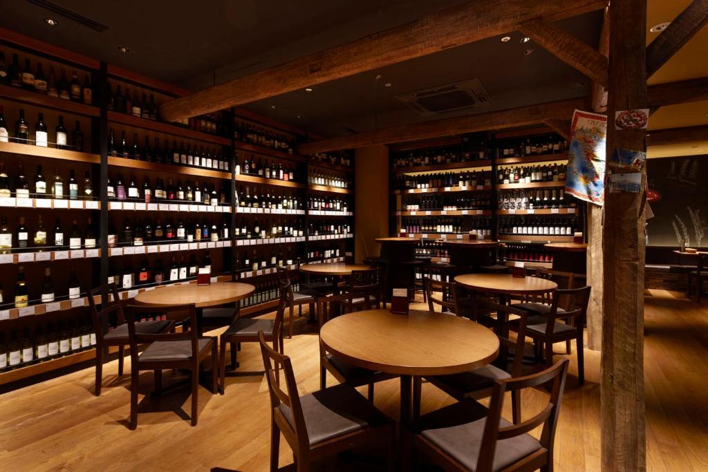 a restaurant with tables and shelves of wine bottles at the b ikebukuro in Tokyo