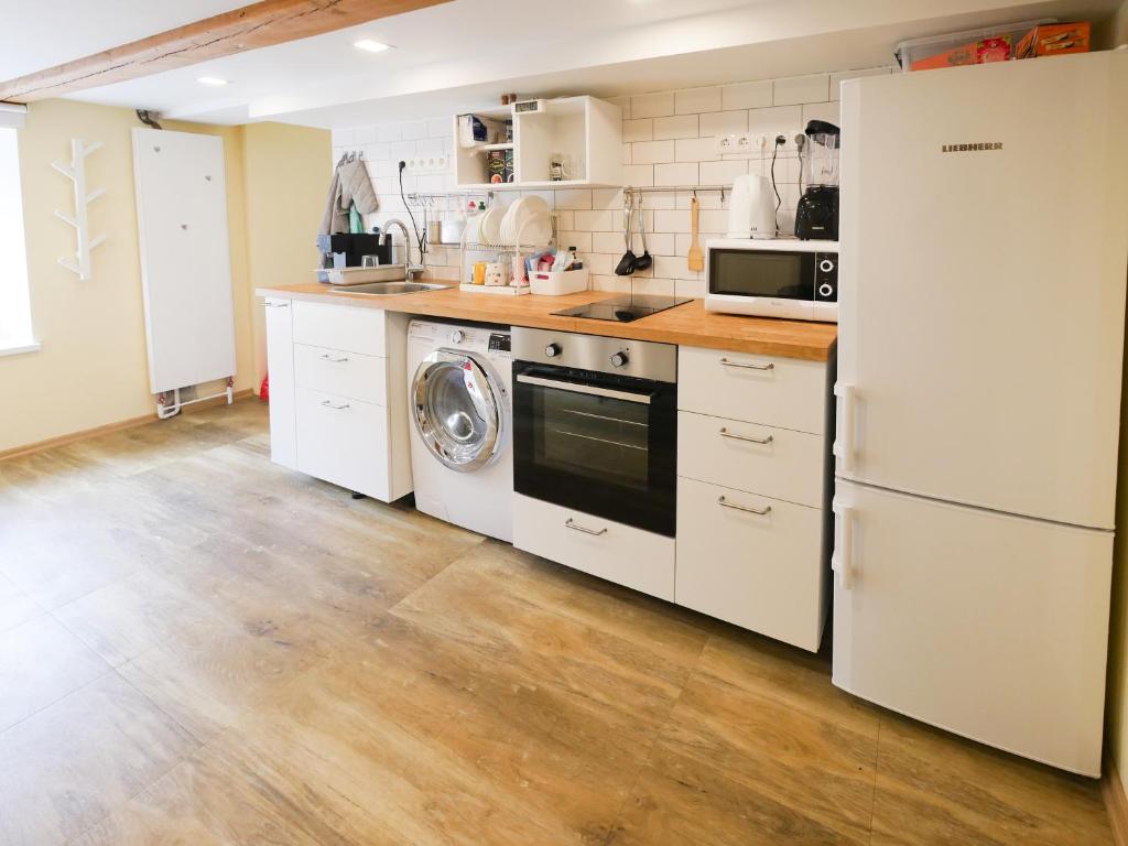 kuchnia z lodówką, pralką i suszarką w obiekcie Low Ceiling Apartment w Rydze