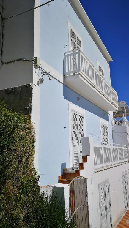 a white house with stairs and a balcony at VisitPonza - Palazzetto Azzurro in Ponza