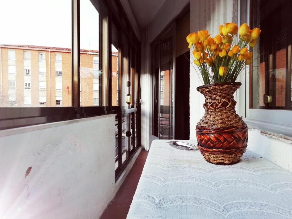 a vase filled with yellow flowers sitting on a table at Pension La Catedral in León