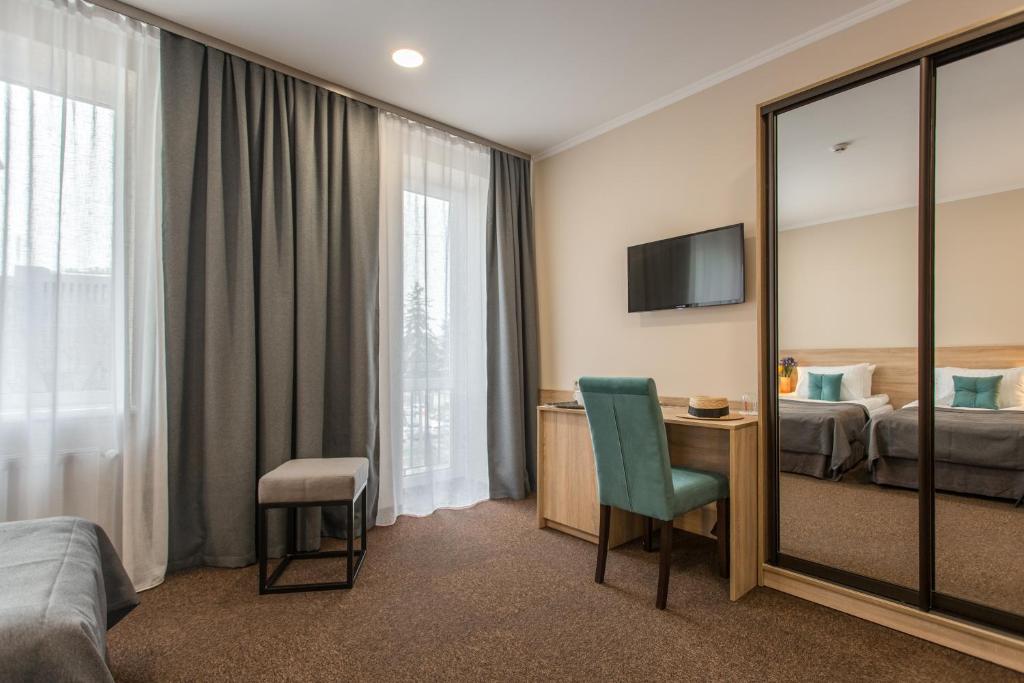 um quarto de hotel com uma cama e um espelho em Nota Bene Loft em Lviv