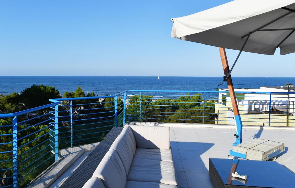 um pátio com um guarda-sol, uma cadeira e o oceano em Residence Gambrinus em Giulianova