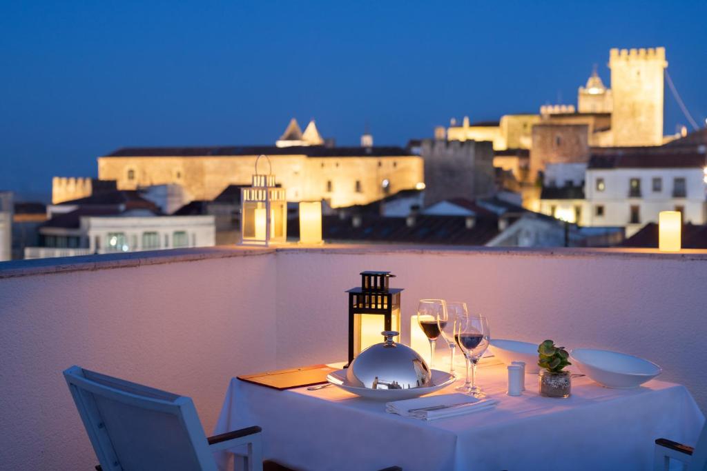 a table with glasses of wine on a balcony at Dorma Agora Cáceres in Cáceres