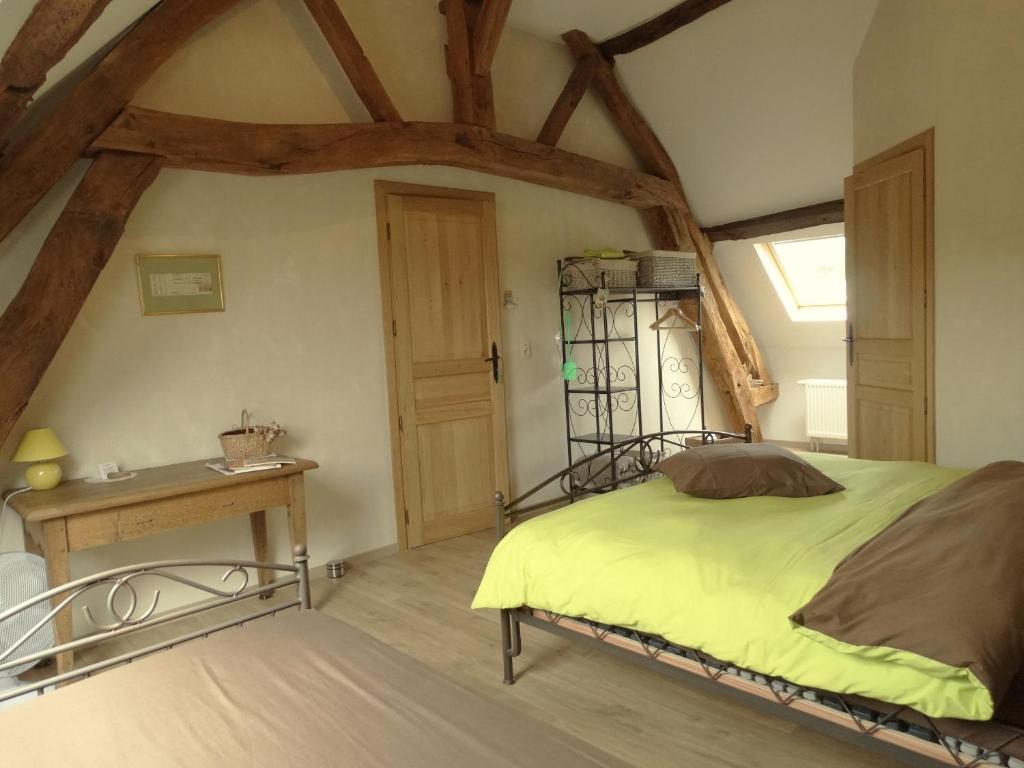1 dormitorio con cama y mesa de madera en La Vannerie en Origny-en-Thiérache
