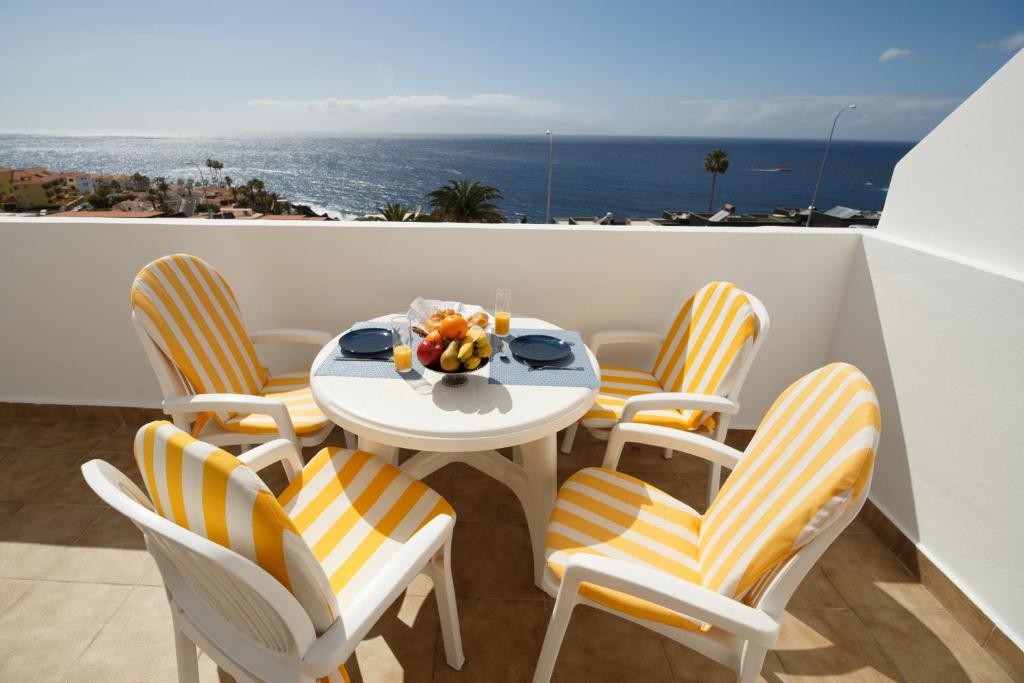 Una mesa y sillas en un balcón con vista al mar. en Elita veradero Nice FREE WIFI, en Puerto de Santiago