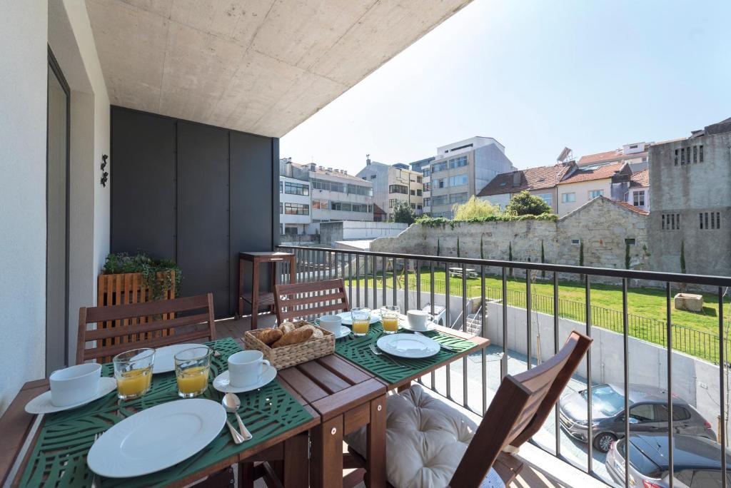 a table on a balcony with a view of the city at LovelyStay - Downtown Balcony Apartment with Free Parking in Porto