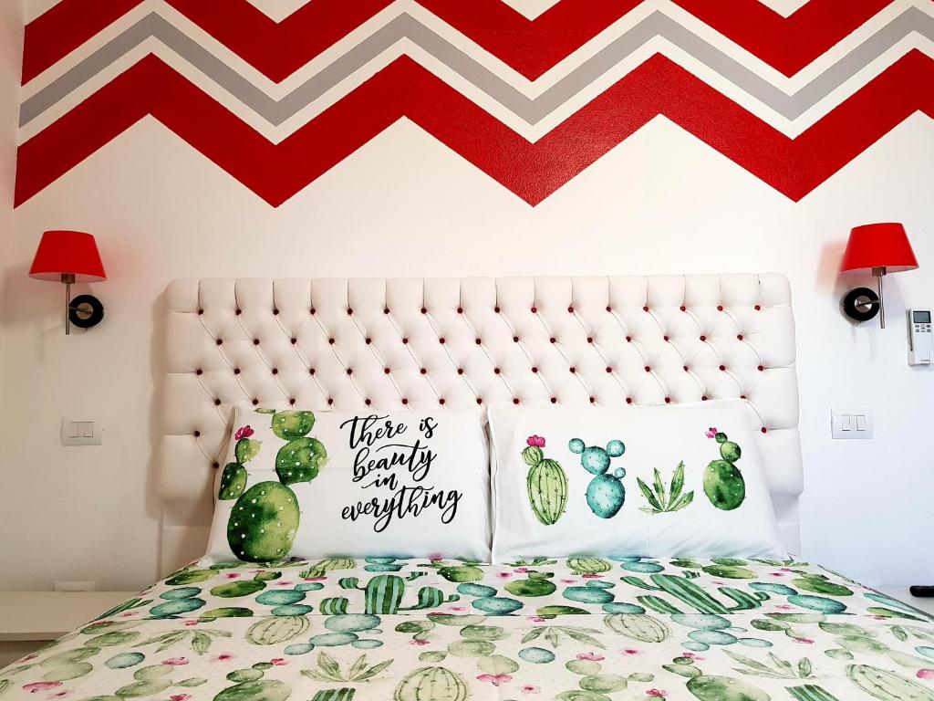 una camera da letto con letto e cuscini di cactus di B&B L'Arcobaleno a Pula