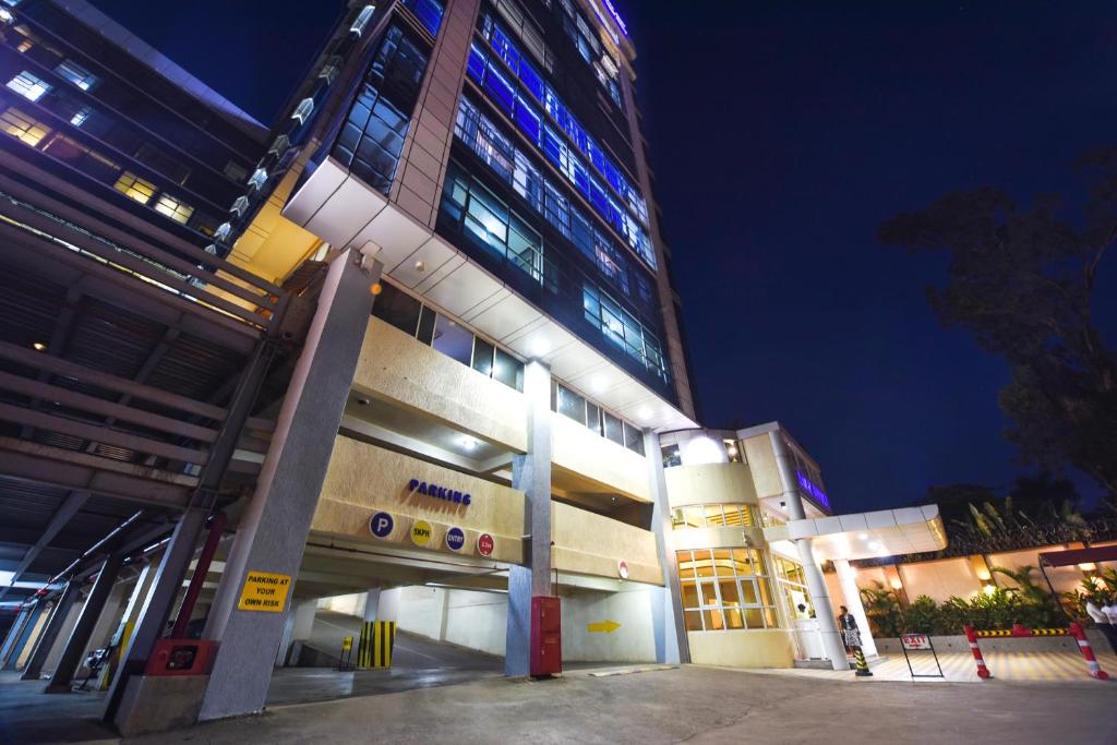 a large building at night with its lights on at BMK House Apartments in Kampala