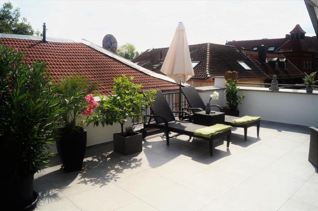 einen Balkon mit Stühlen, einem Sonnenschirm und Pflanzen in der Unterkunft Altstadtherz in Bad Kreuznach