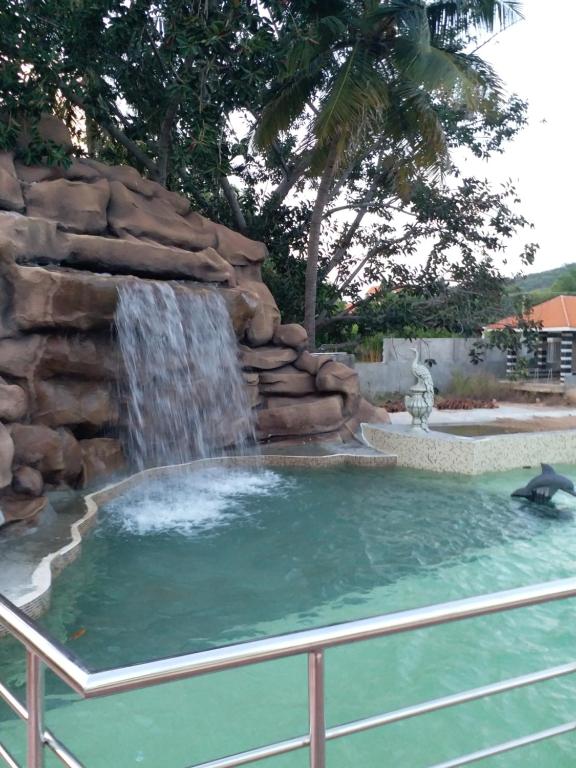 Mount Retreat Resorts - Madurai في مادوراي: مسبح مع شلال في حديقه خلفيه