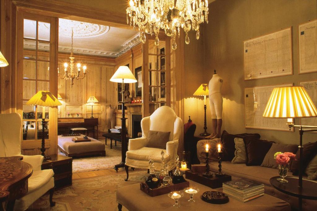 a living room with a chandelier and a couch and chair at The Pand Hotel - Small Luxury Hotels of the World in Bruges