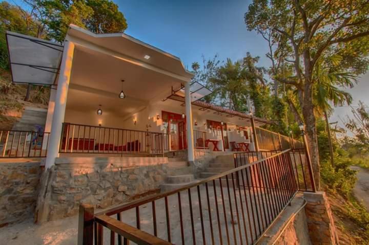 a large house with a porch with a fence at V@Ella guesthouse in Ella