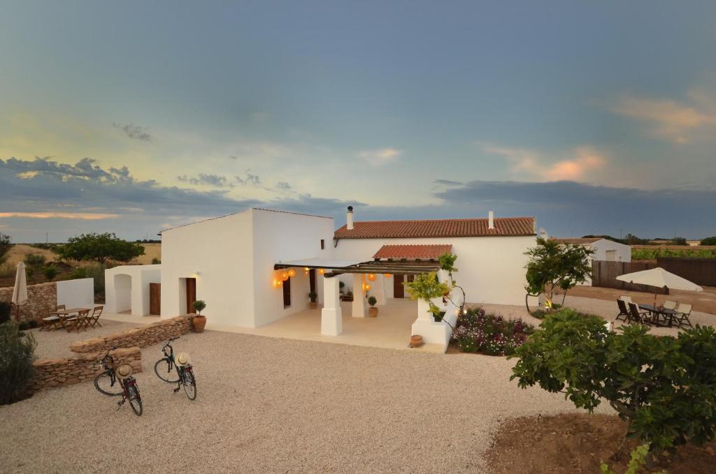 una casa blanca con bicicletas estacionadas frente a ella en Villa Can Vicent Puig en La Mola