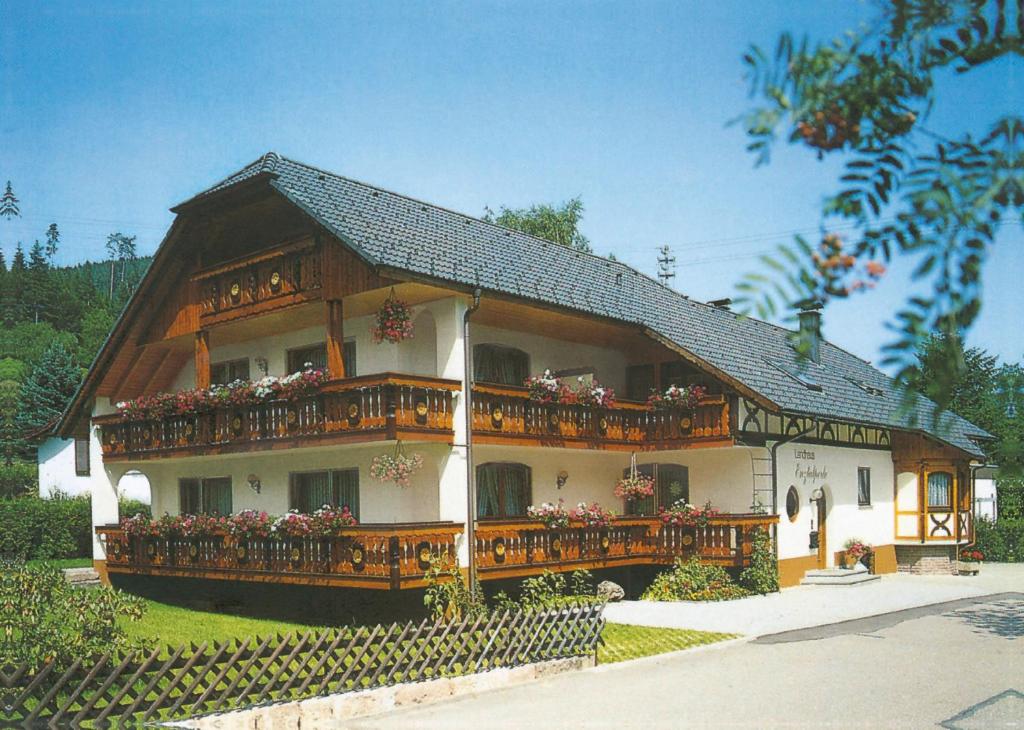 una casa con un balcón con flores. en Ferienwohnung ENZTALPERLE, en Enzklösterle