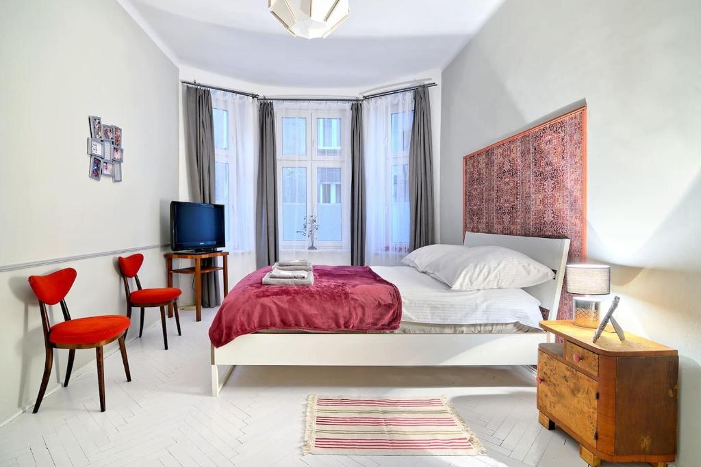 een witte slaapkamer met een bed en een televisie bij Luxury Retro Apartment, City Center, WiFi in Krakau