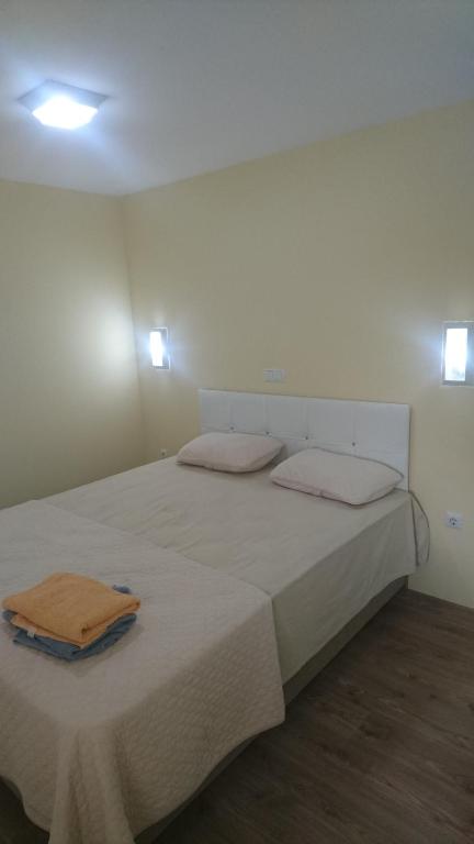 Una cama blanca con dos almohadas encima. en Kumbaz Pansiyon en Sapanca
