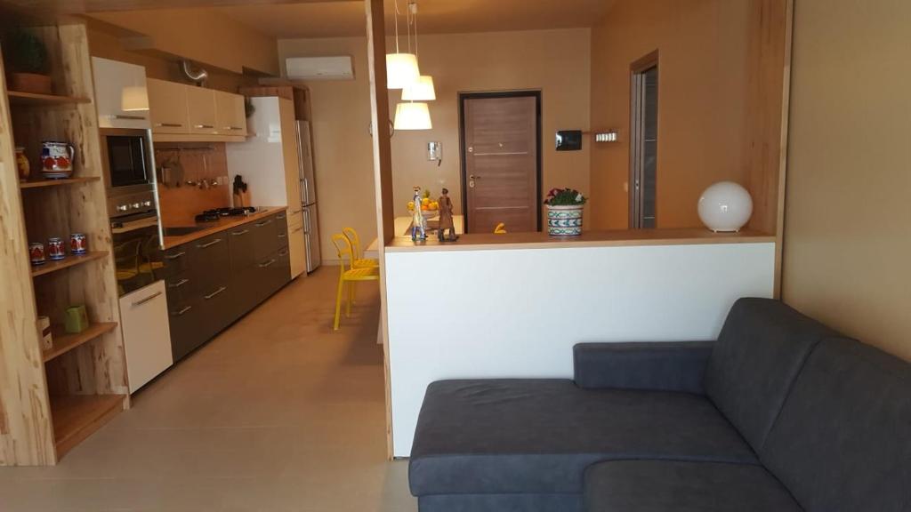 a kitchen and a living room with a couch in a room at Anteo holiday house in Riposto