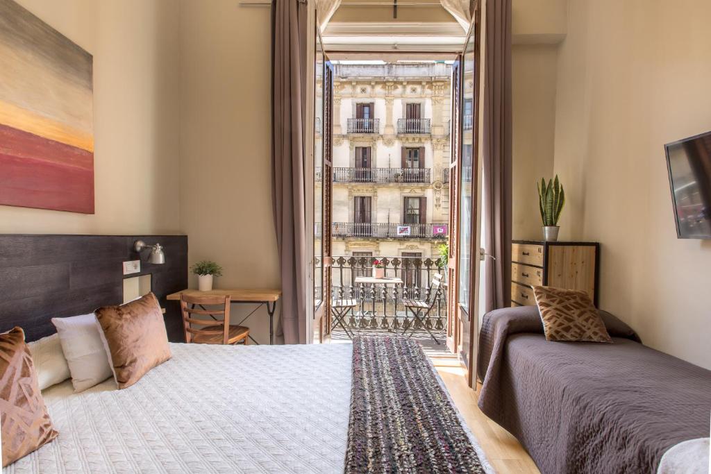 een slaapkamer met een bed en uitzicht op een gebouw bij El Born Guest House by Casa Consell in Barcelona