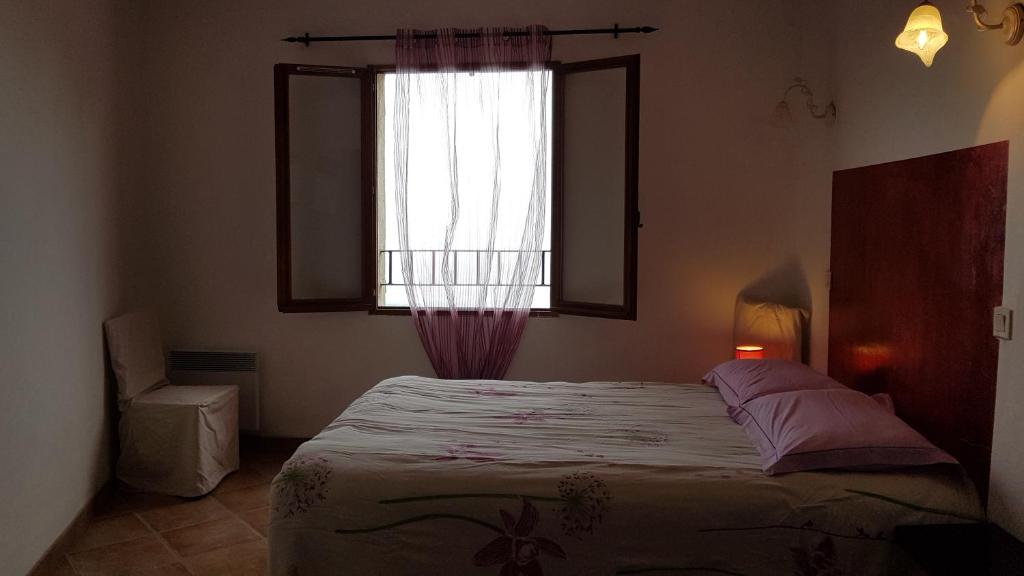 a bedroom with a large bed and a window at Gîte La Fontaine Corse in Loreto-di-Casinca