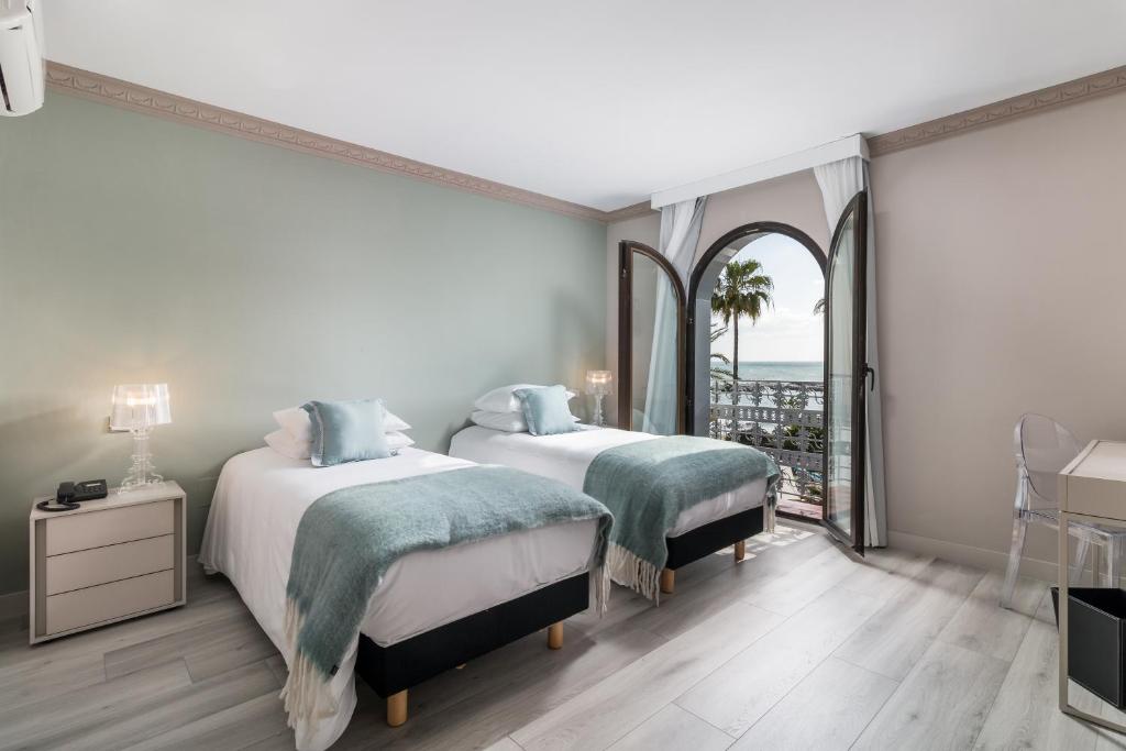 twee bedden in een slaapkamer met uitzicht op de oceaan bij Boutique Hotel B51 in Marbella