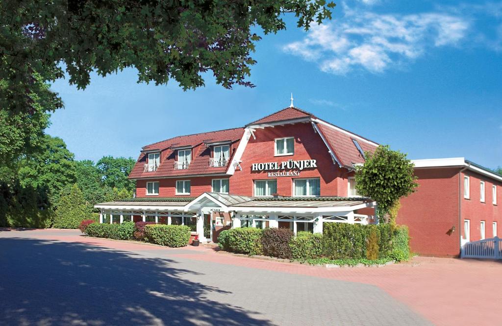 um grande edifício de tijolos vermelhos com um guarda-florestal do hotel em HOTEL PÜNJER em Witzhave