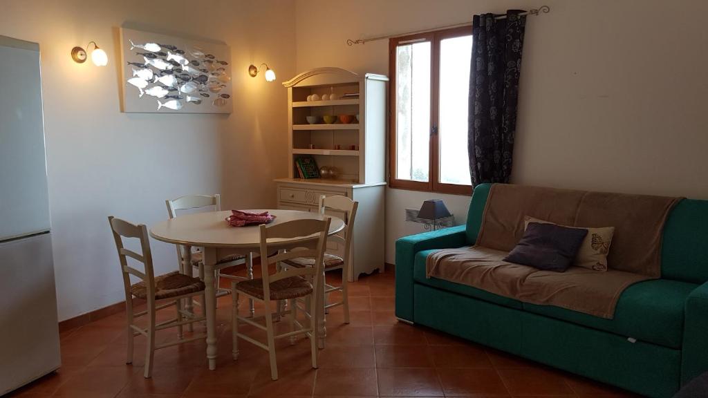 a living room with a table and a couch at Gîte La Fontaine Corse in Loreto-di-Casinca