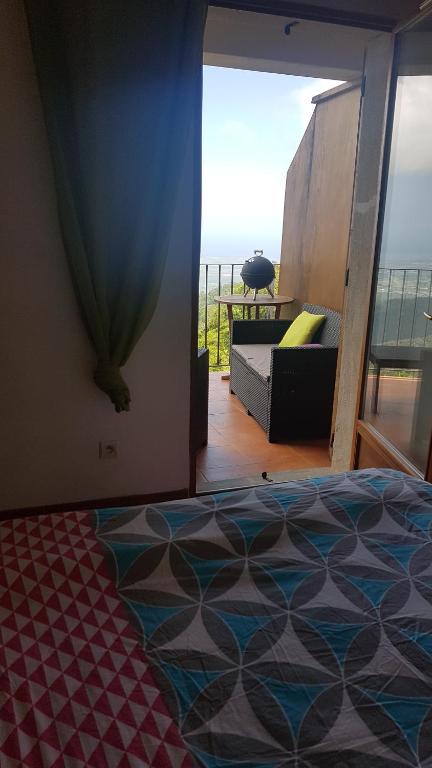 a bedroom with a bed and a view of the ocean at Gîte La Fontaine Corse in Loreto-di-Casinca